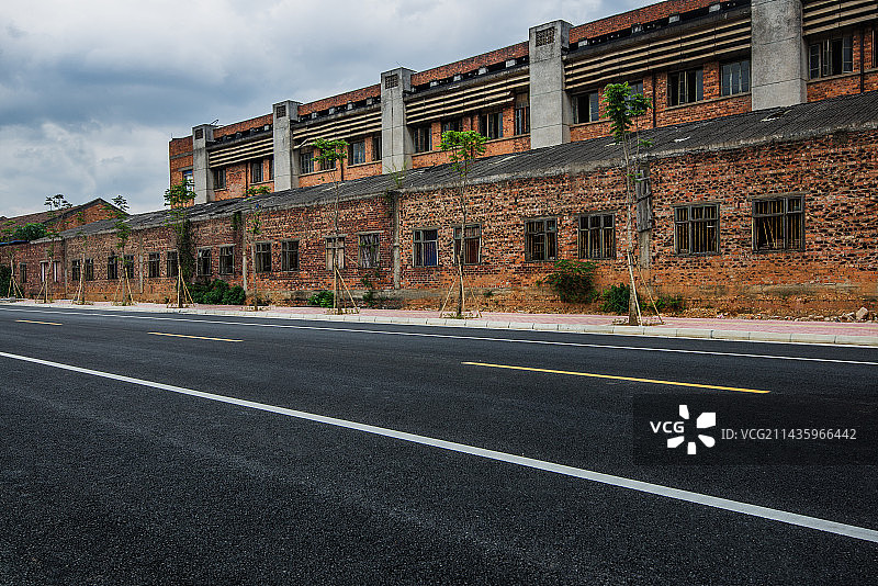 旧厂房外笔直向前的沥青道路图片素材