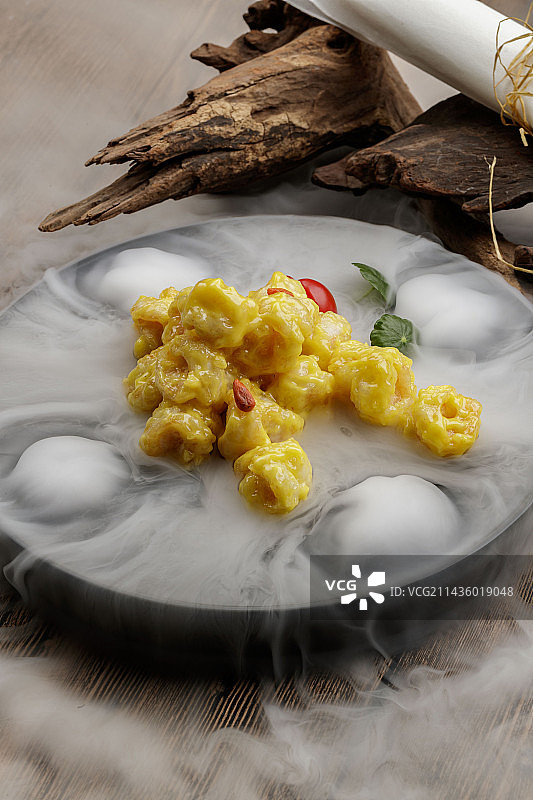 干冰缭绕的餐具摆放的芥香焗虾球图片素材