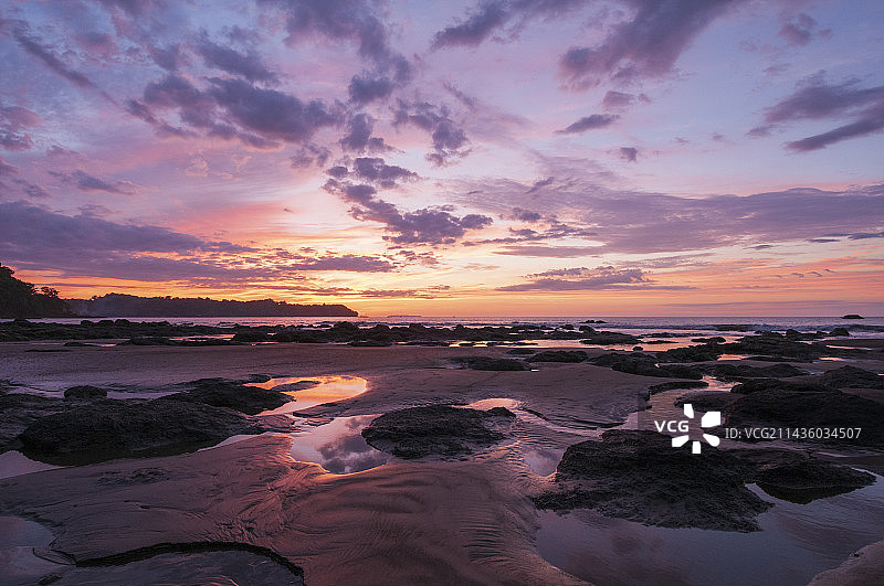 日落时分海滩上的水坑和沙堆图片素材