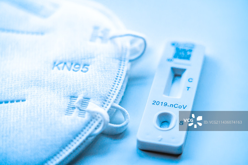 白色背景下的Covid-19抗原试剂盒和口罩——新冠肺炎防护与检测图片素材