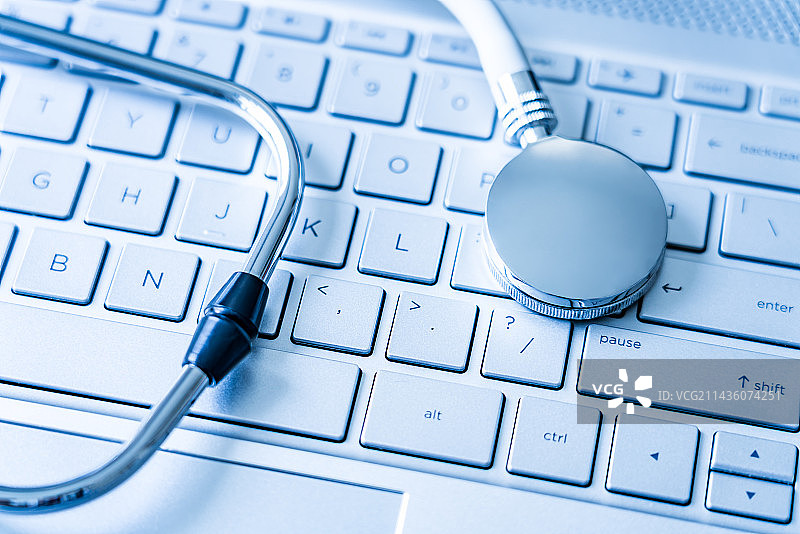 听诊器放在银色电脑键盘上——健康医疗概念图片素材