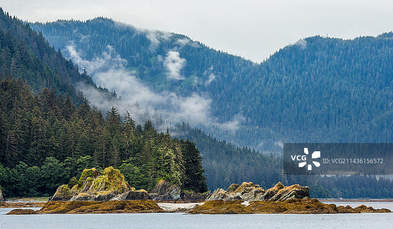 从海上眺望阿拉斯加峡湾山脉和森林的壮丽景色图片素材