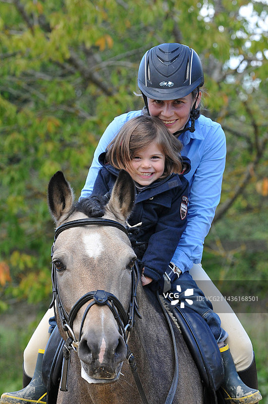 骑在新森林种马上的女人和一个小女孩——家庭与马图片素材