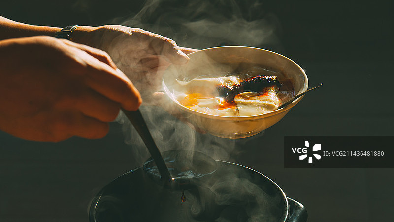 在黑色背景下准备食物的人的特写镜头图片素材