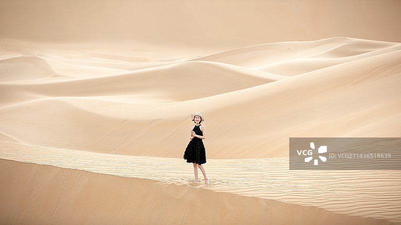 在内蒙古沙漠中行走的年轻少女，20岁女孩图片素材