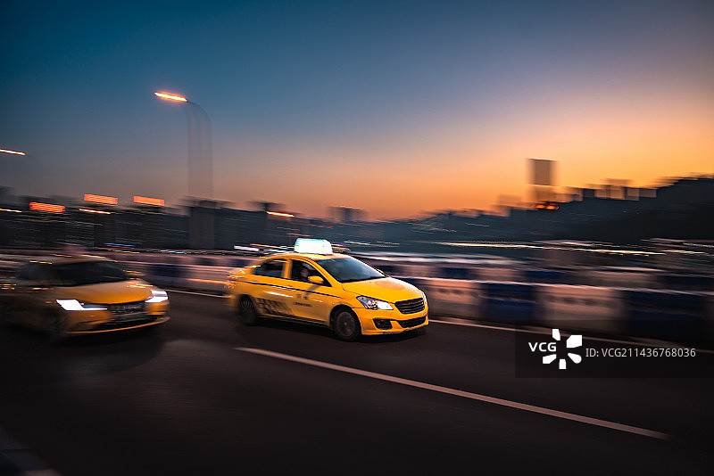 重庆城市公路上飞驰的黄色出租车图片素材