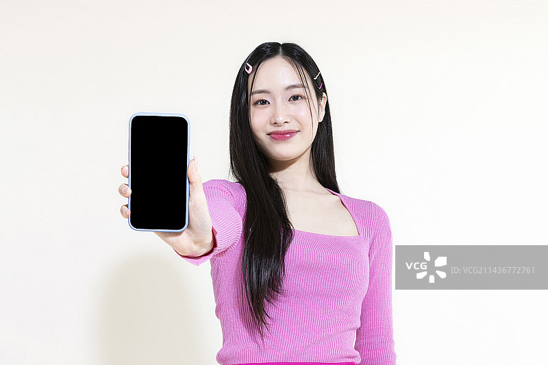 Y2K粉色复古概念照片：手持智能手机的亚洲女性图片素材