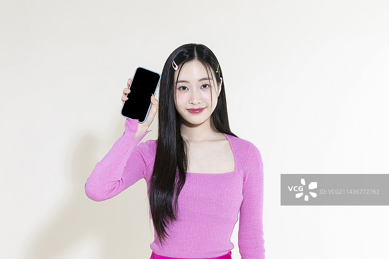 Y2K粉色复古概念照片：手持智能手机的亚洲女性图片素材