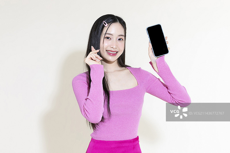 Y2K粉色复古概念照片：手持智能手机的亚洲女性图片素材