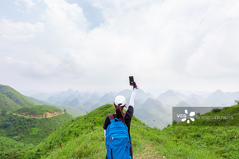 户外徒步的年轻女性，手机图片素材