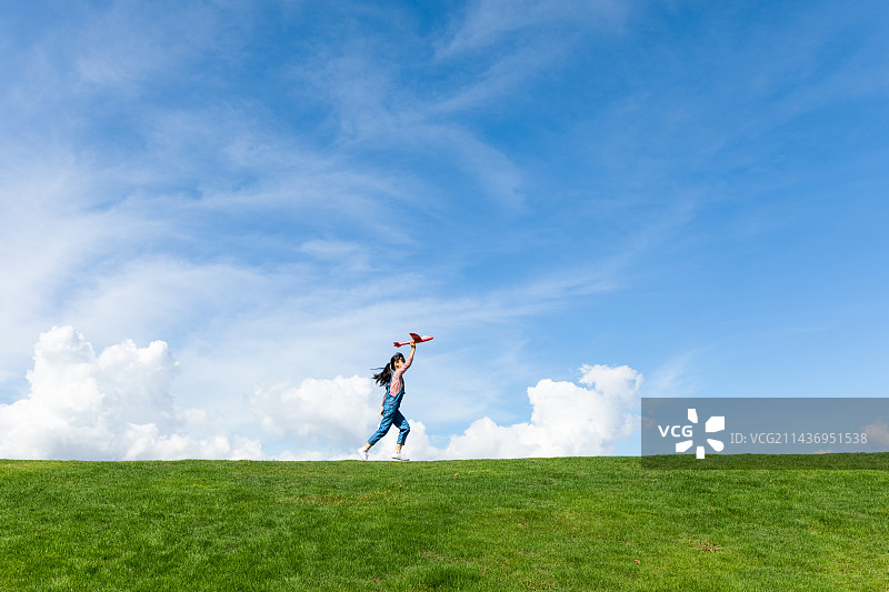 蓝天白云下一名小女孩在玩飞机图片素材