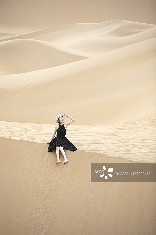 沙漠中的沙丘上的女人图片素材