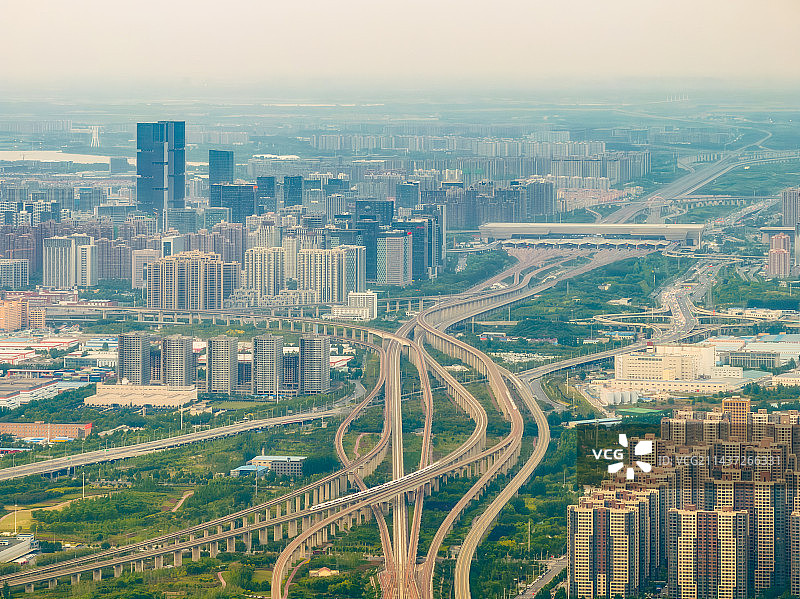 河南省郑州市京广高铁、郑渝高铁、郑阜高铁、机场快线等四通八达的高铁网络综合枢纽与郑州东站春季户外航拍图片素材