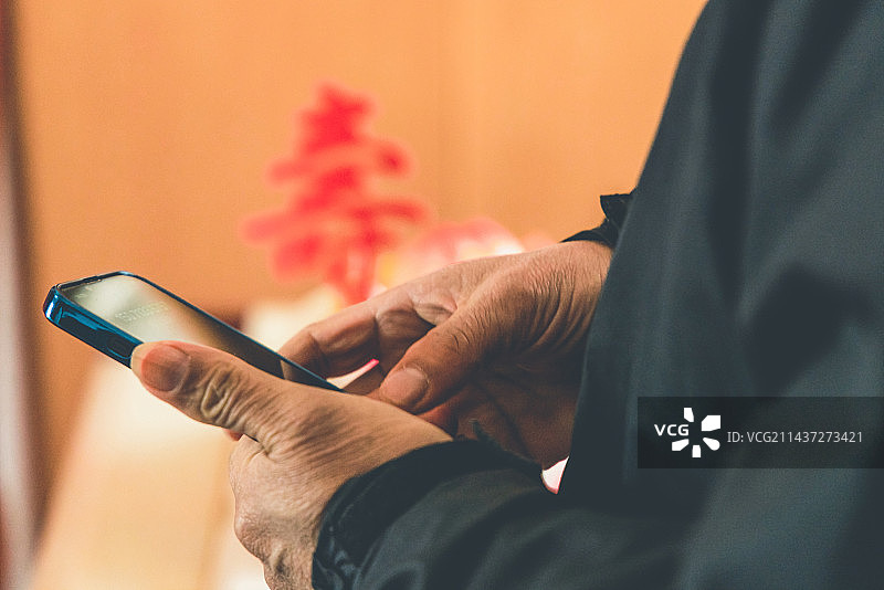 生日派对上，手拿手机图片素材