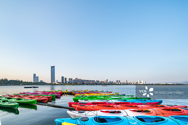 成都天府新区兴隆湖白昼晴天城市风光和色彩鲜艳的皮划艇图片素材