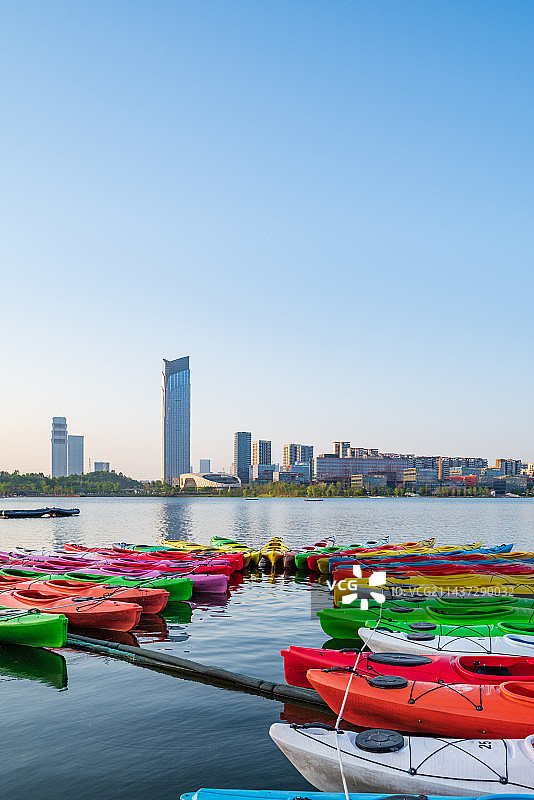 成都天府新区兴隆湖白昼晴天城市风光和色彩鲜艳的皮划艇图片素材