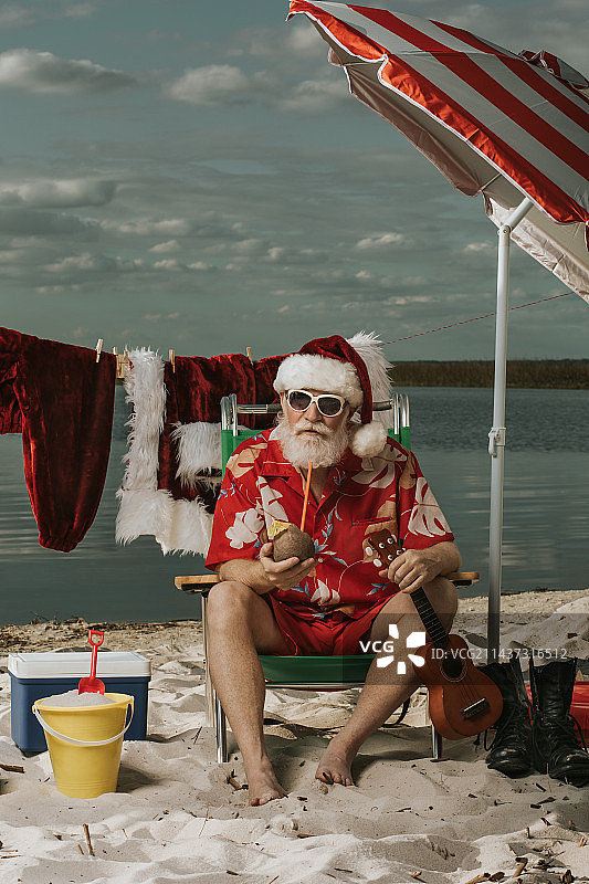 男人扮圣诞老人坐在佛罗里达州圣克劳德海滩的沙滩上图片素材