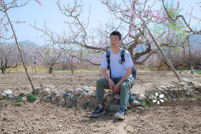 甘肃省兰州市皋兰县什川古梨园-坐在梨园的年轻人图片素材