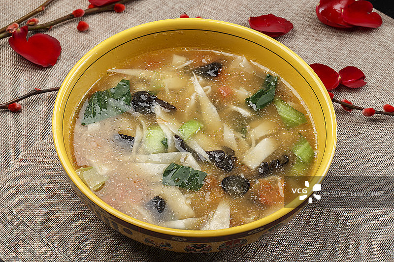 黄色瓷盆装的西红柿面片汤图片素材