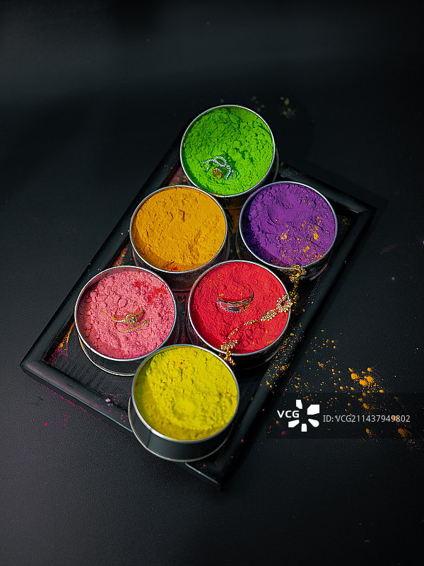 黑色背景下容器中彩色粉末涂料的高角度视图图片素材