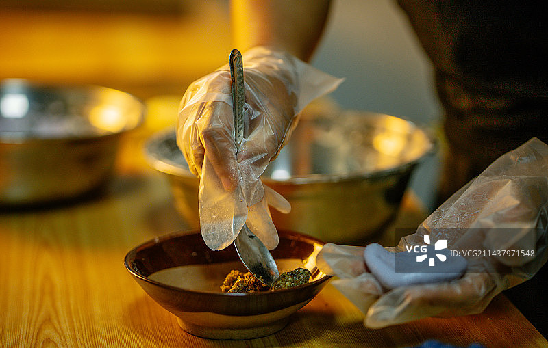 贵州省黔西南布依族苗族自治州望谟县蟠桃街道甘莱村，向糯米粉团加入芝麻、花生、红糖、猪油等熬制的馅料。图片素材