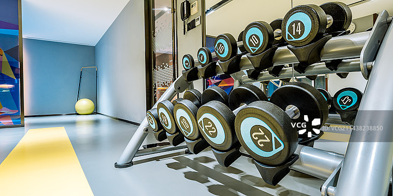 室内小型健身房里的哑铃和健身器材图片素材