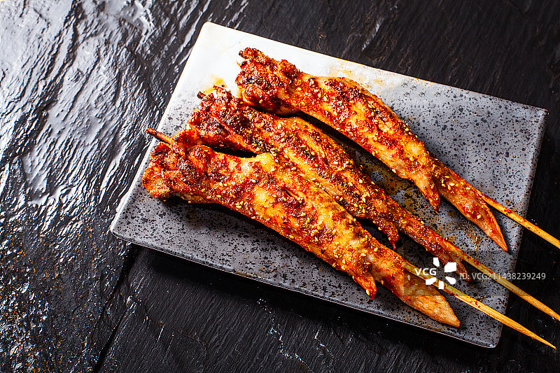 黑色背景上放的烧鸡翅图片素材