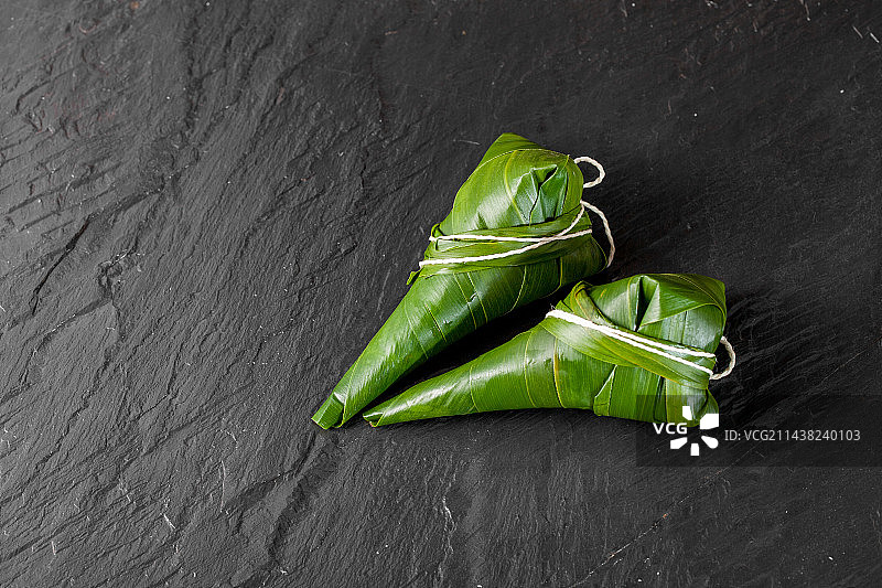 黑色石板上放这江苏粽子图片素材