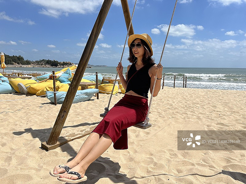 海边荡秋千的东方女人图片素材