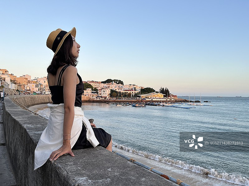 海边阳光下快乐的东方女性图片素材