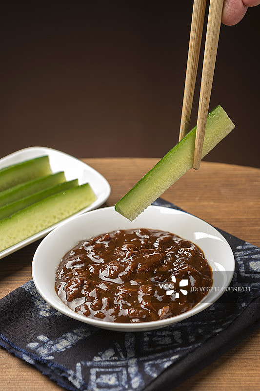 夏季凉菜黄瓜蘸黄豆酱特写木桌面背景图片素材