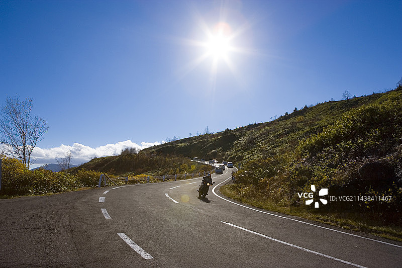 在岩手县八幡平Aspiite线路上行驶的汽车和摩托车图片素材