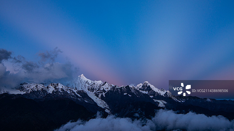 云南德钦梅里雪山-晨光出现—日出前反云隙光汇聚雪山之巅图片素材