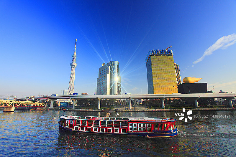 东京晴空塔与波光粼粼的隅田川及游船，东京台东区图片素材