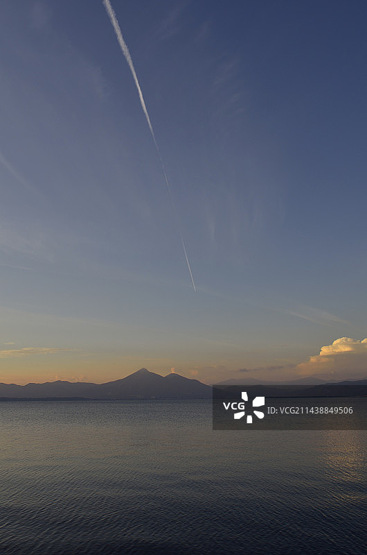 有凝结尾迹的傍晚天空：磐梯高原和猪苗代湖，福岛县郡山市图片素材