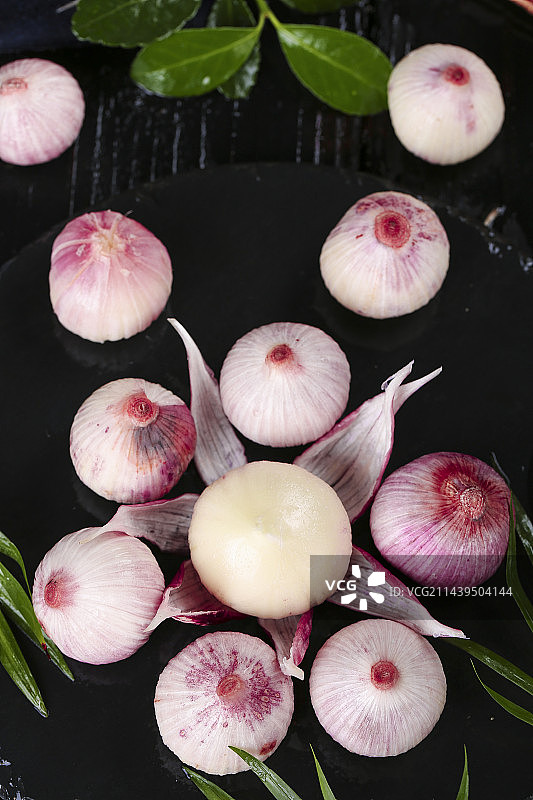 黑底上放着剥皮的独蒜头图片素材