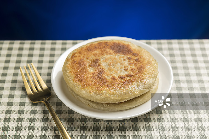 一盘牛肉饼摆放在格子桌布上特写图片素材