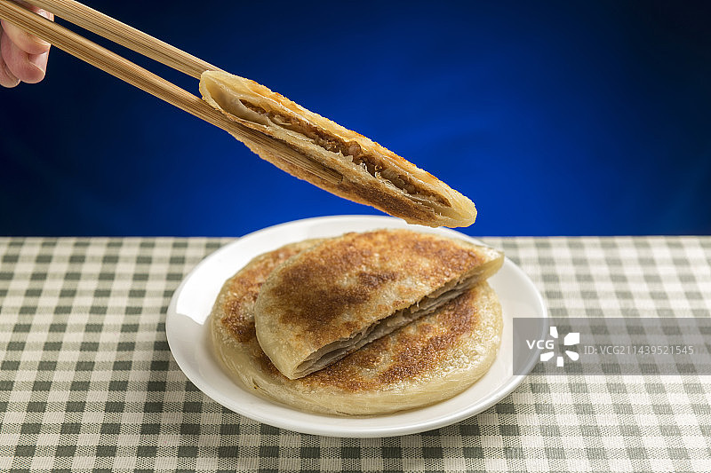 一盘牛肉饼摆放在格子桌布上特写图片素材