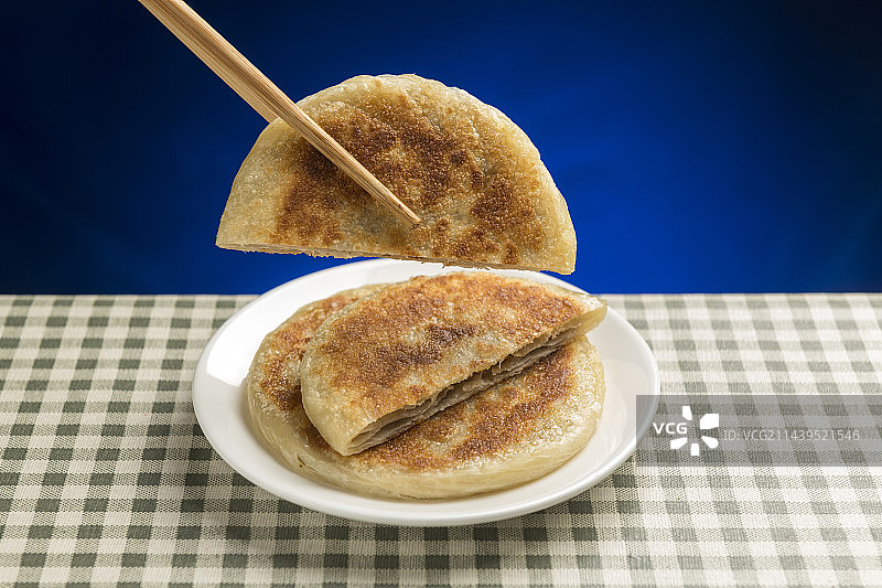 一盘牛肉饼摆放在格子桌布上特写图片素材