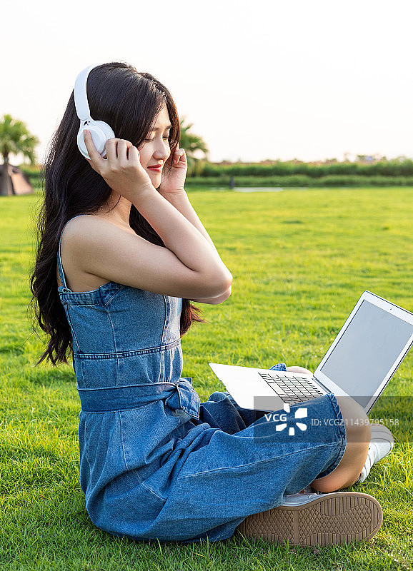 在公园草地上办公的中国商务女性图片素材