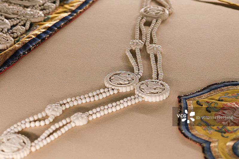 清代黄色缎绣缀硨磲珠璎珞衣图片素材