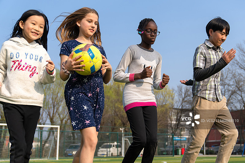 可爱的小学生们在草地上玩耍图片素材