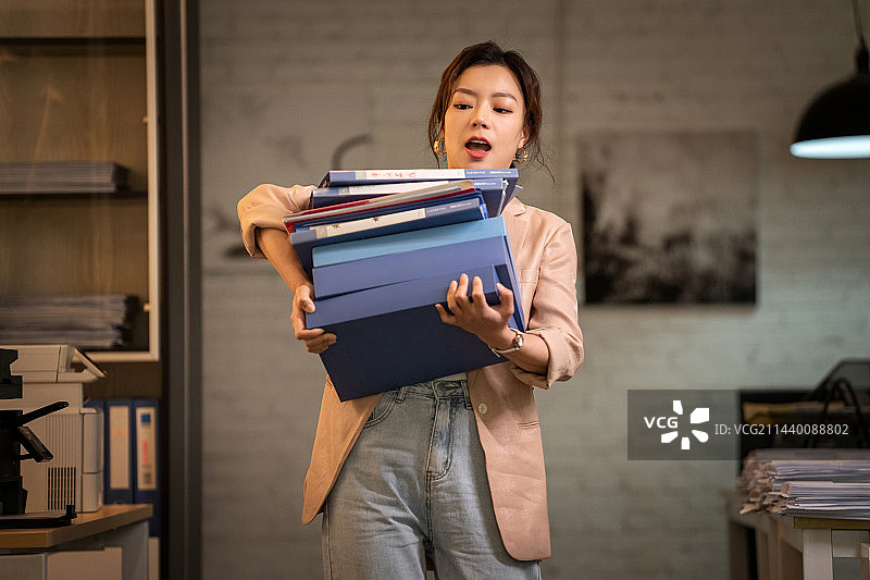 青年职业女性抱着一摞文件夹图片素材
