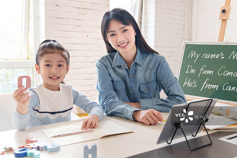 家教老师辅导小学生学习英语图片素材