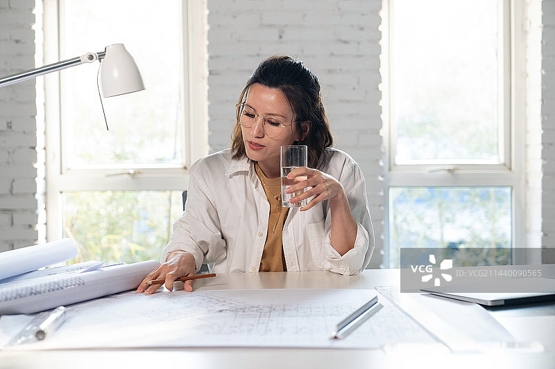 室内画图纸的青年设计师图片素材