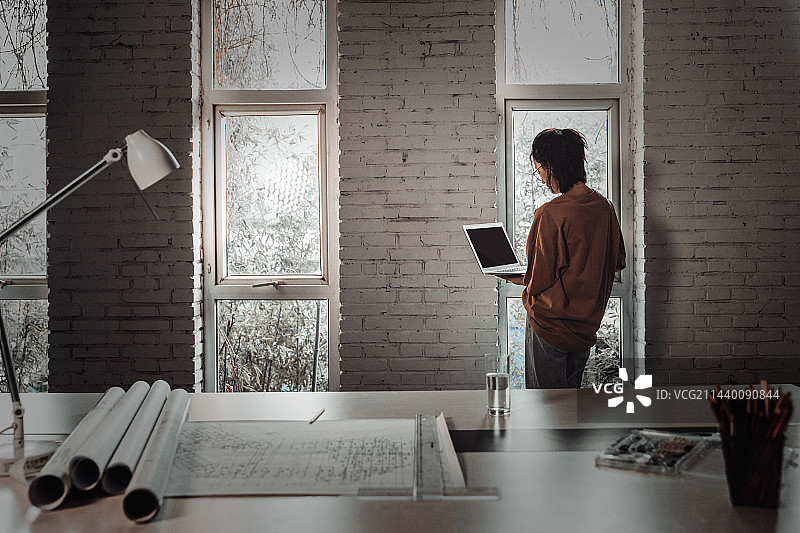 室内使用笔记本电脑的青年设计师图片素材
