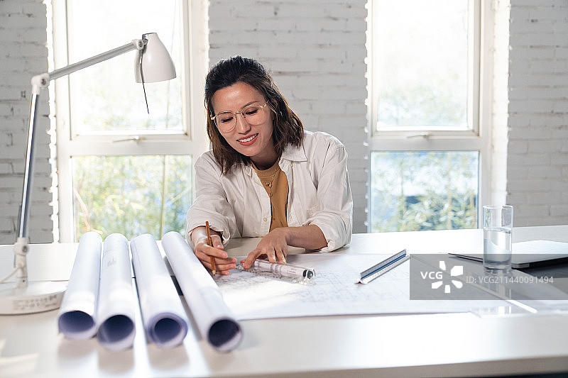 室内画图纸的青年设计师图片素材