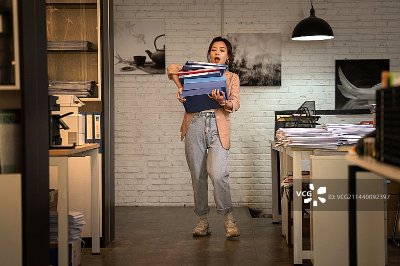 青年职业女性抱着一摞文件夹图片素材