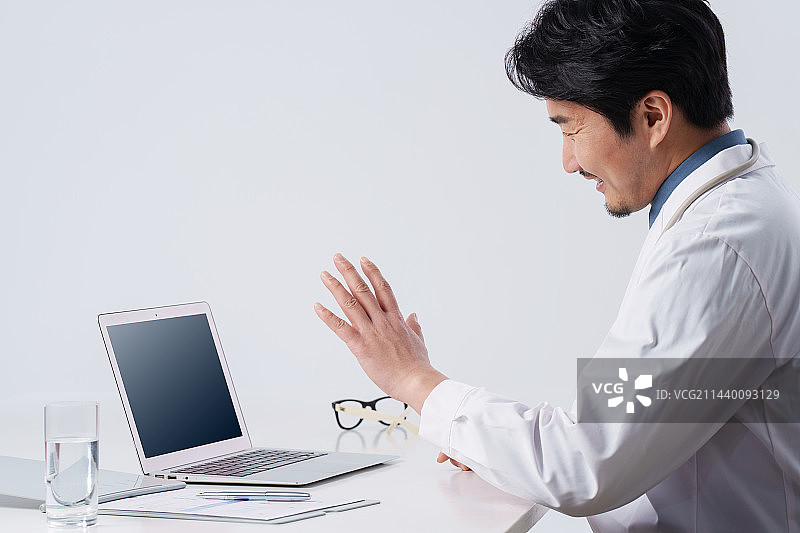 线上问诊的中年男医生图片素材