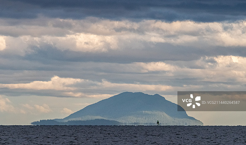 海上岛屿的海市蜃楼和冲浪的人图片素材